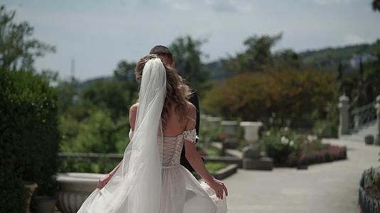 在城市里年轻的新娘和新郎在风雨中挥舞着面纱视频的预览图