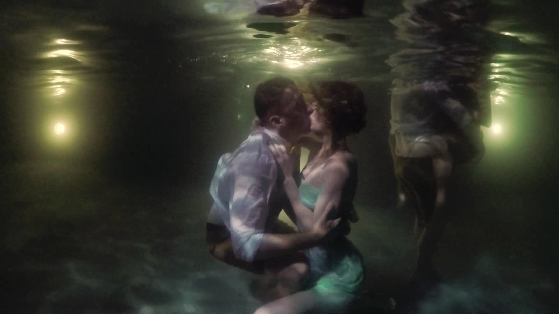晚上 年轻、性感、可爱的情侣们在游泳池里拥抱和亲吻水下浪漫视频的预览图