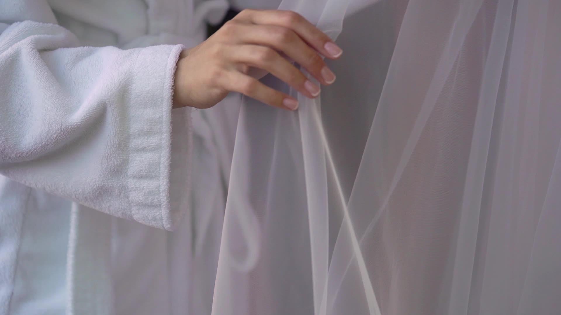 帮助年轻新娘穿上婚纱的伴娘视频的预览图