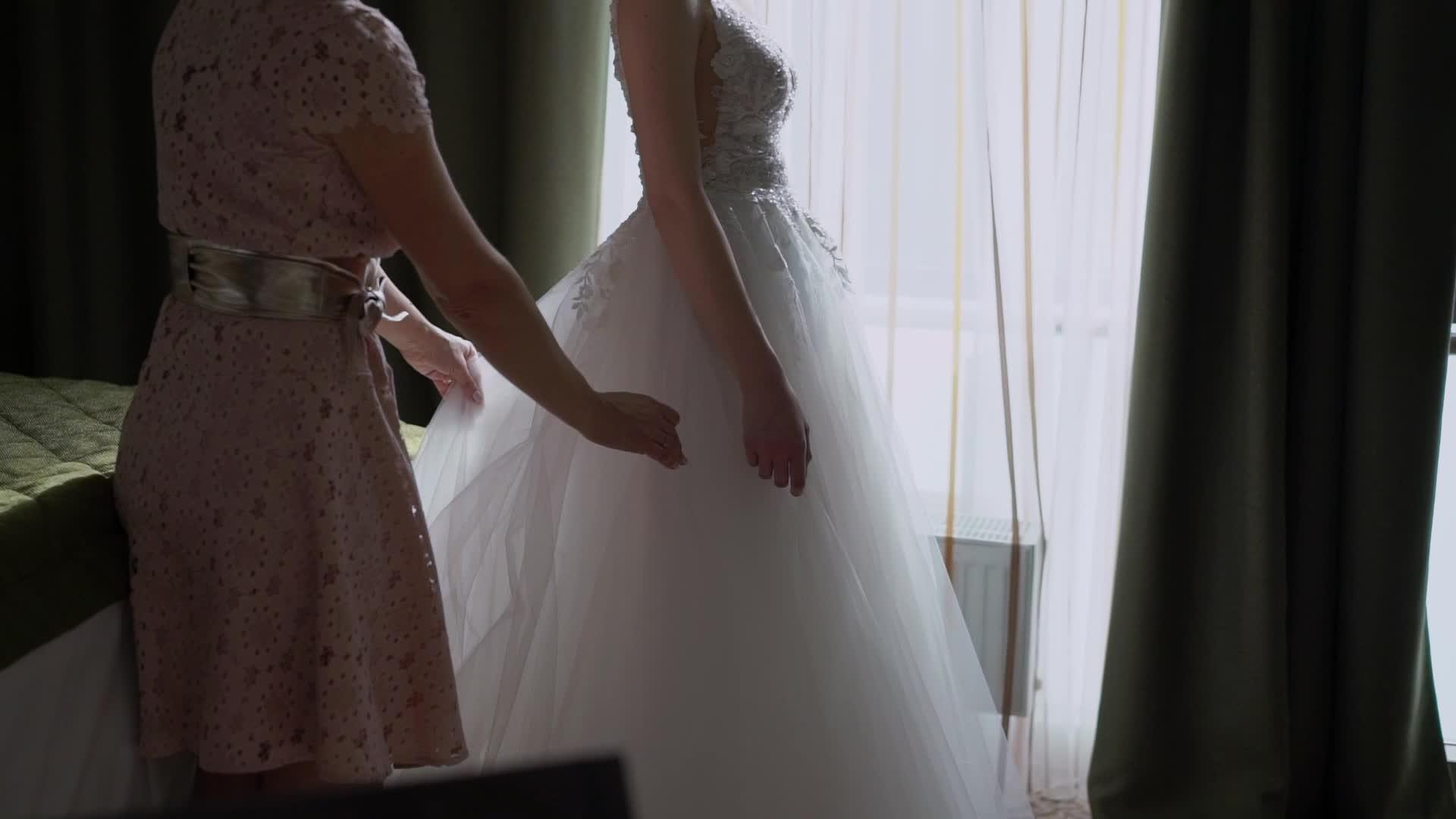 伴娘帮助年轻新娘穿上婚纱奢华的婚纱视频的预览图