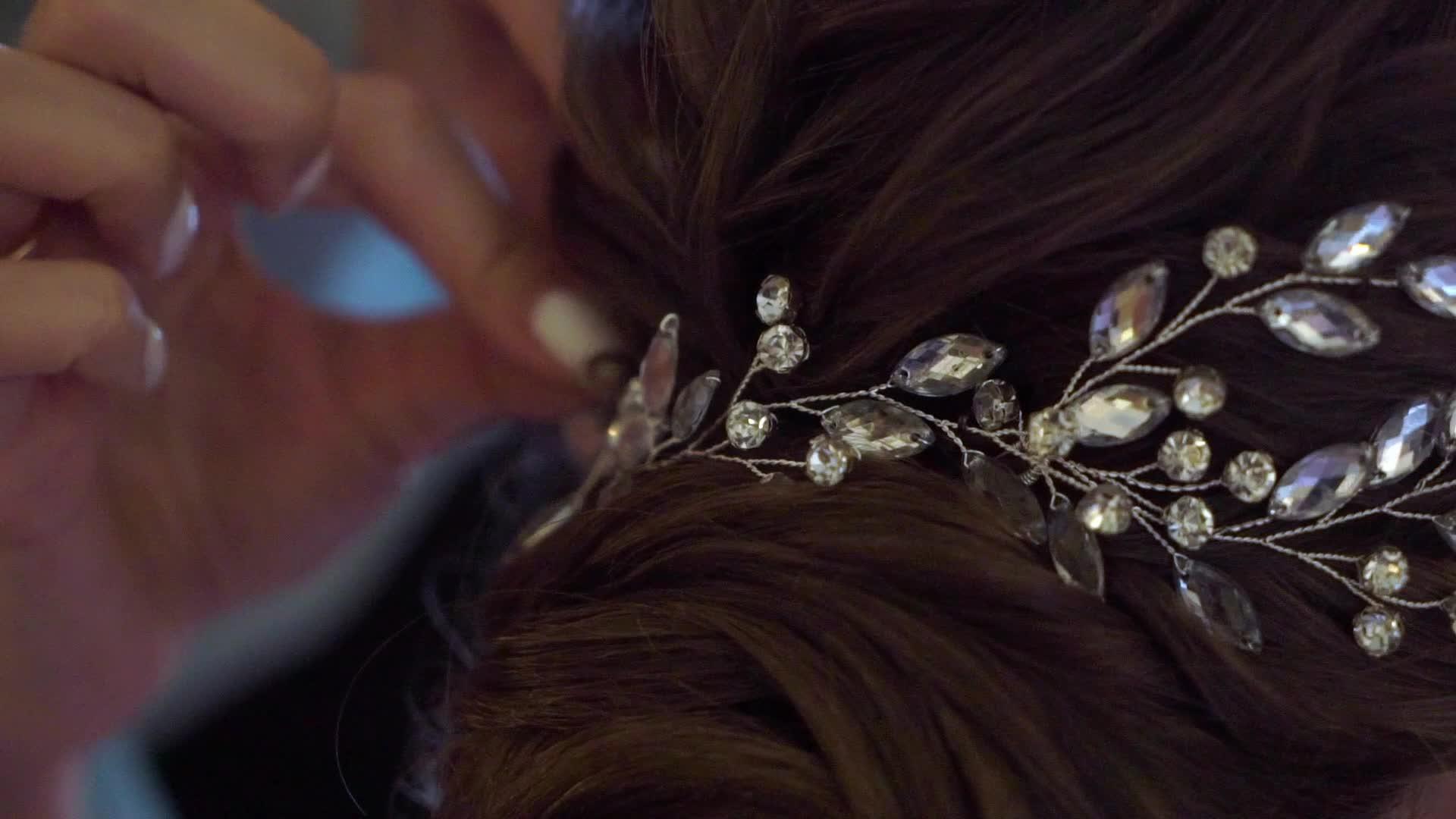 头发上的珠宝装饰着女人的发型美发师和黑发新娘在婚礼上视频的预览图