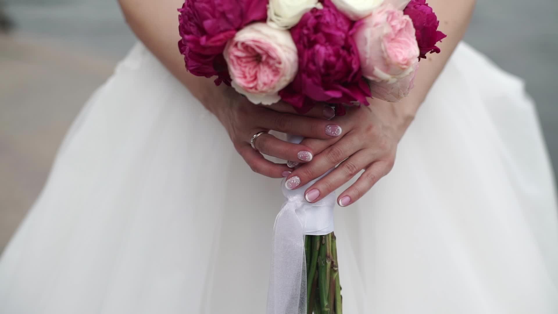 新娘挥舞着丝带白色的粉色和红色的玫瑰花束视频的预览图
