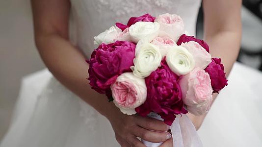 新娘挥舞着丝带白色的粉色和红色的玫瑰花束视频的预览图