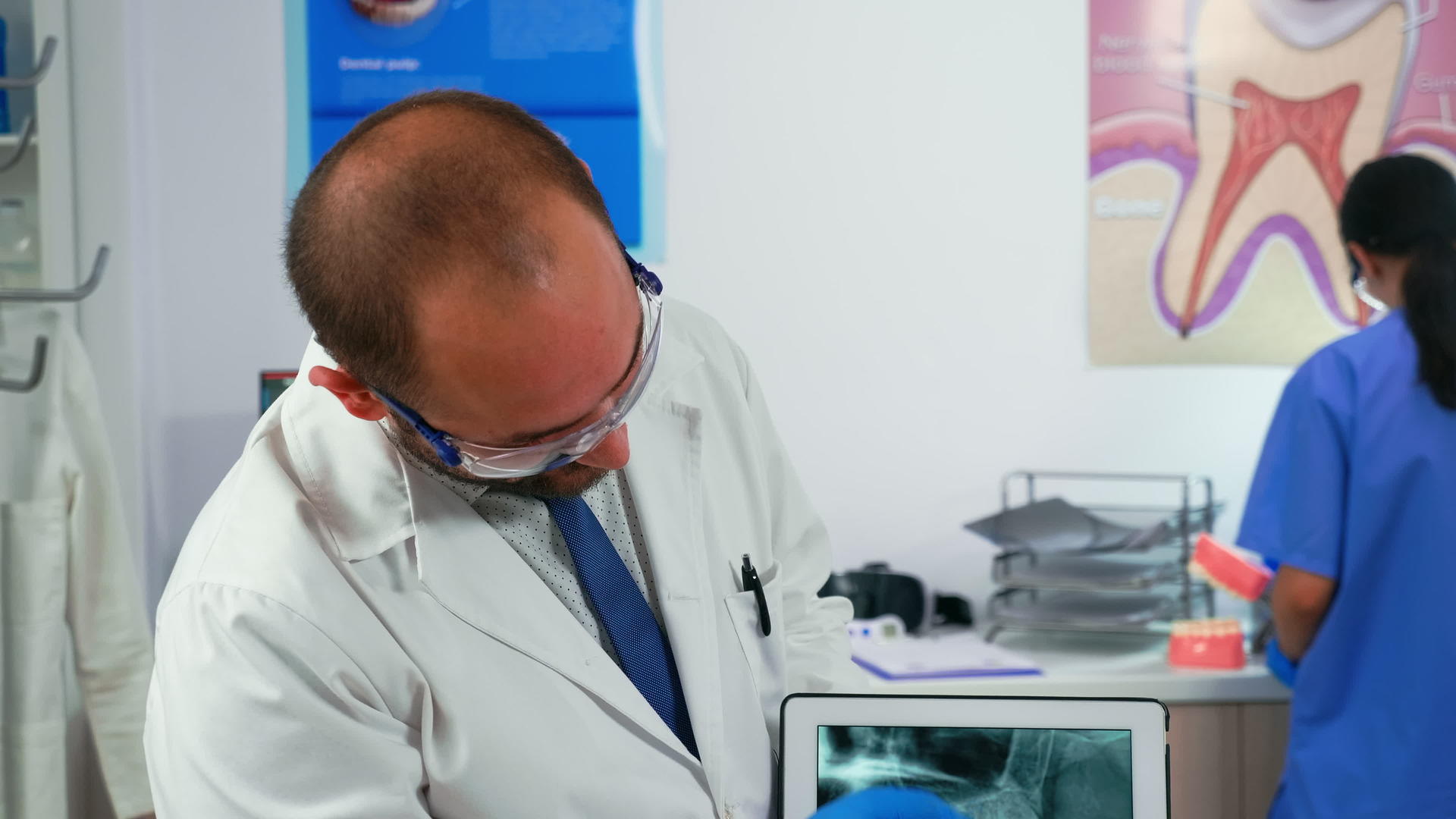 医生用下巴向病人展示平板药片视频的预览图