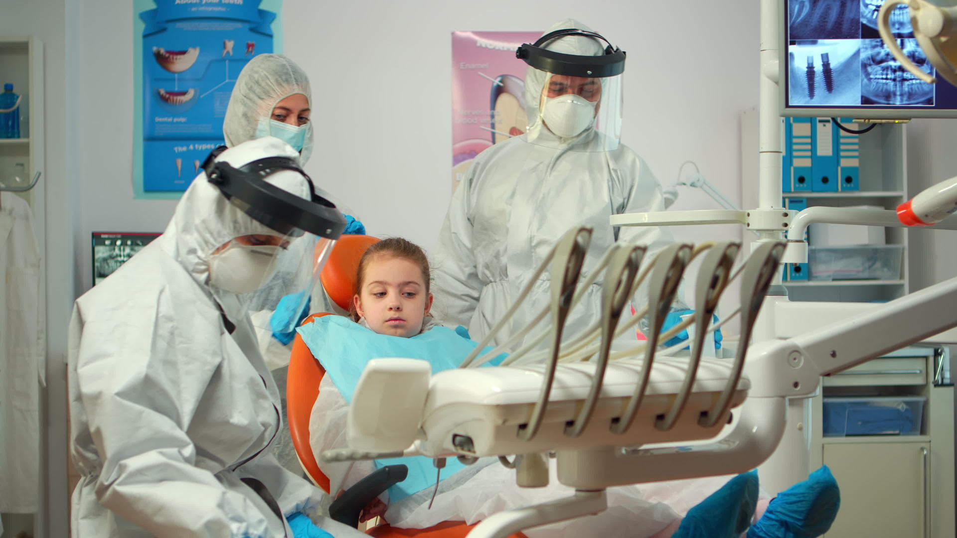 穿着防护服的儿科牙医正在检查前照灯视频的预览图