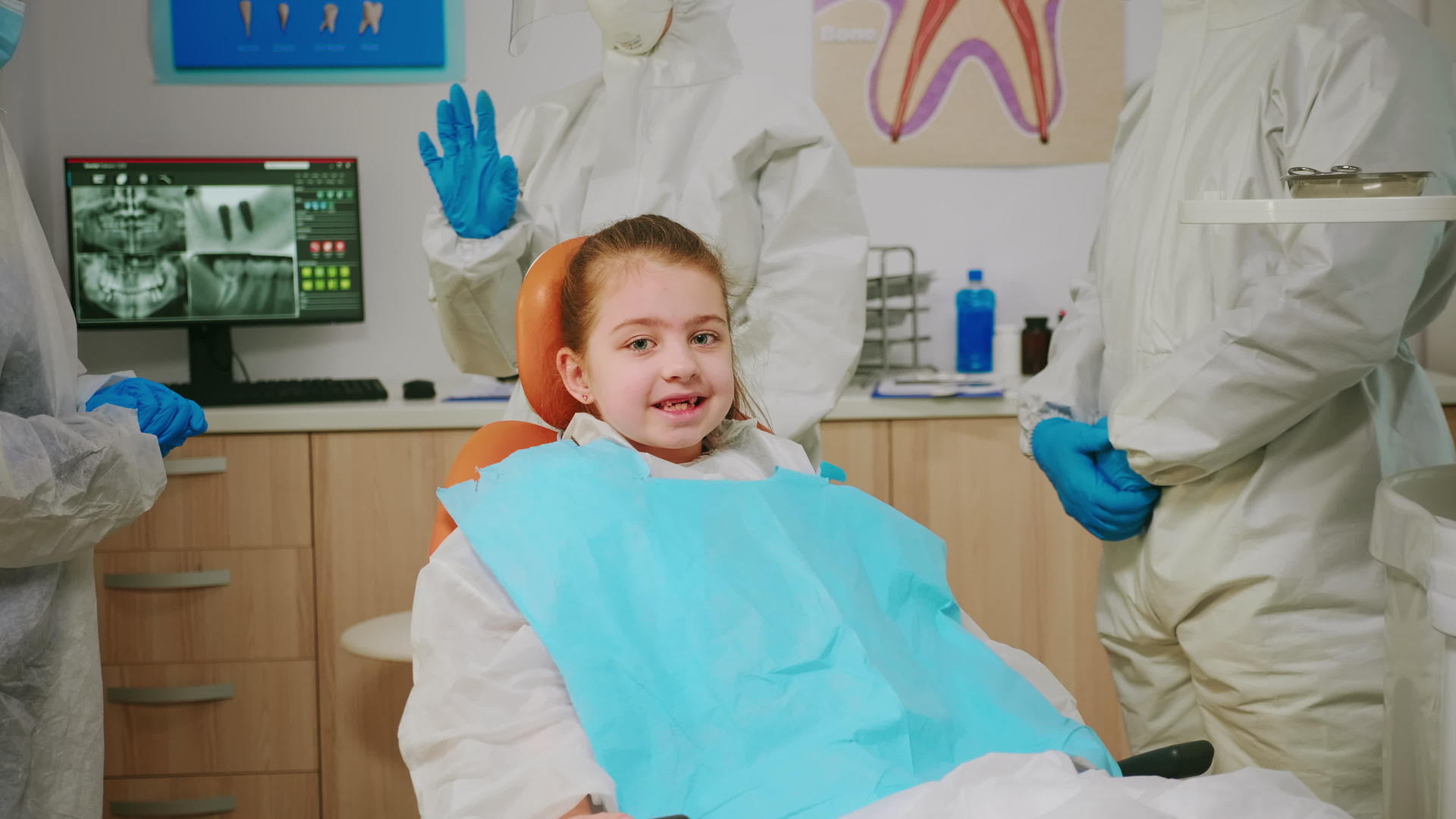 在全球流行期间快乐的女孩微笑着看牙医访问全球视频的预览图