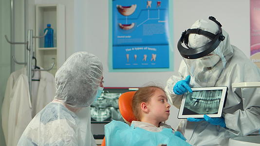 牙科牙医在儿童平板牙医X光片上显示的保护设备中视频的预览图