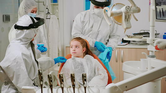 保险人的牙医护士在检查前向儿童患者提供牙科诊断书视频的预览图