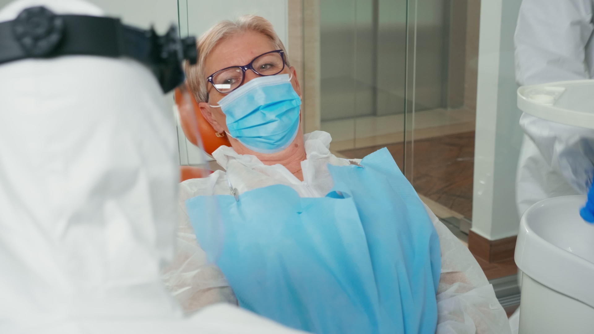 老年患者戴口罩听牙医咨询视频的预览图