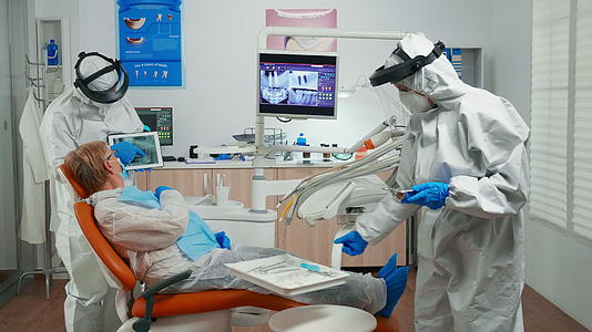 西装保护医生讨论使用平板电脑进行X光检查视频的预览图