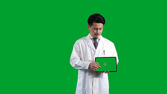 白大褂男医生展示平板电脑绿幕视频的预览图