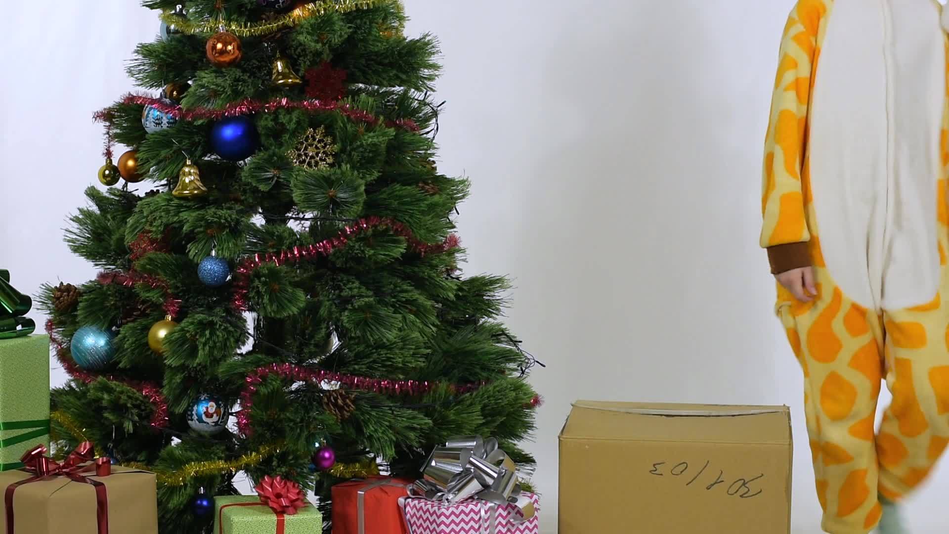 女孩拉着盒子坐在圣诞树旁边视频的预览图