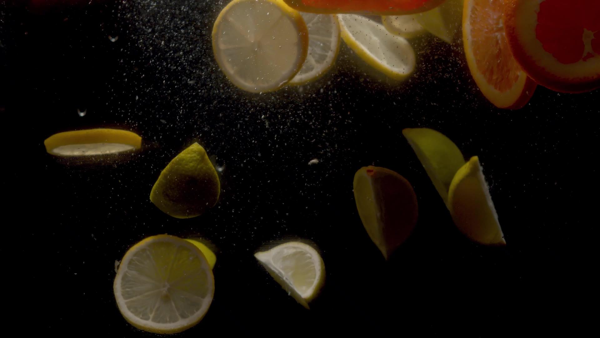 切片柠檬和橘子掉入水中视频的预览图