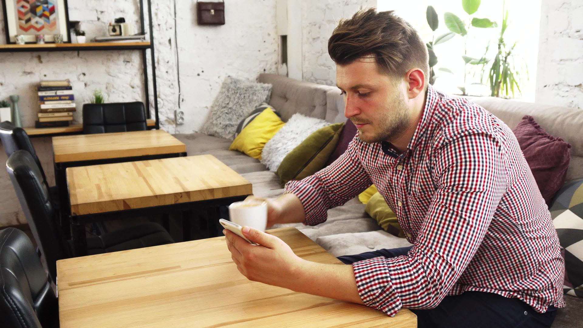 顾客喝咖啡时用他的电话喝咖啡视频的预览图