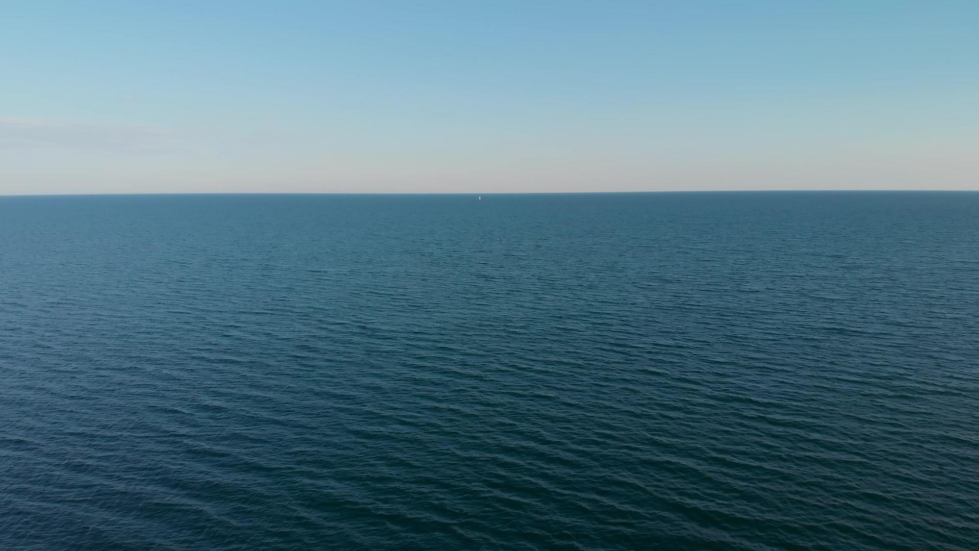 一艘孤独的白色游艇在海平线上高空航行视频的预览图