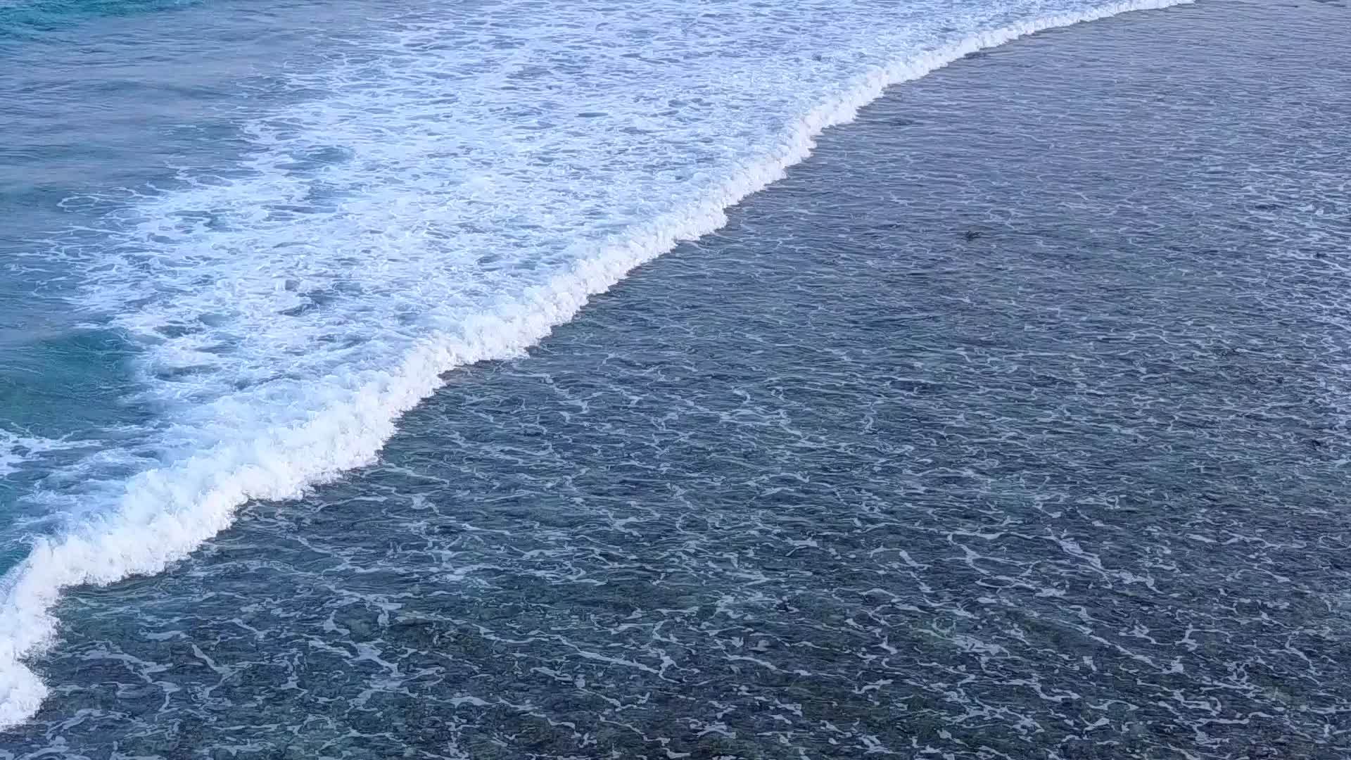 清澈的海洋和接近海浪的白沙背景符合环礁湖的宁静背景视频的预览图