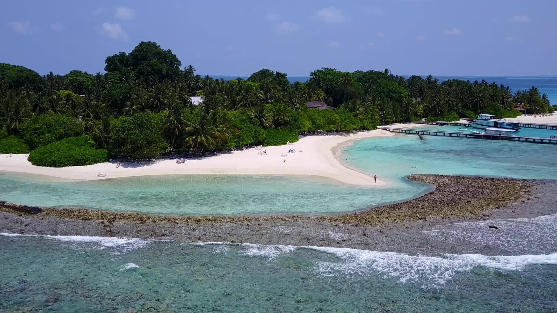 阳光明媚的海滨休闲海滩以蓝水和白色海滩为背景视频的预览图