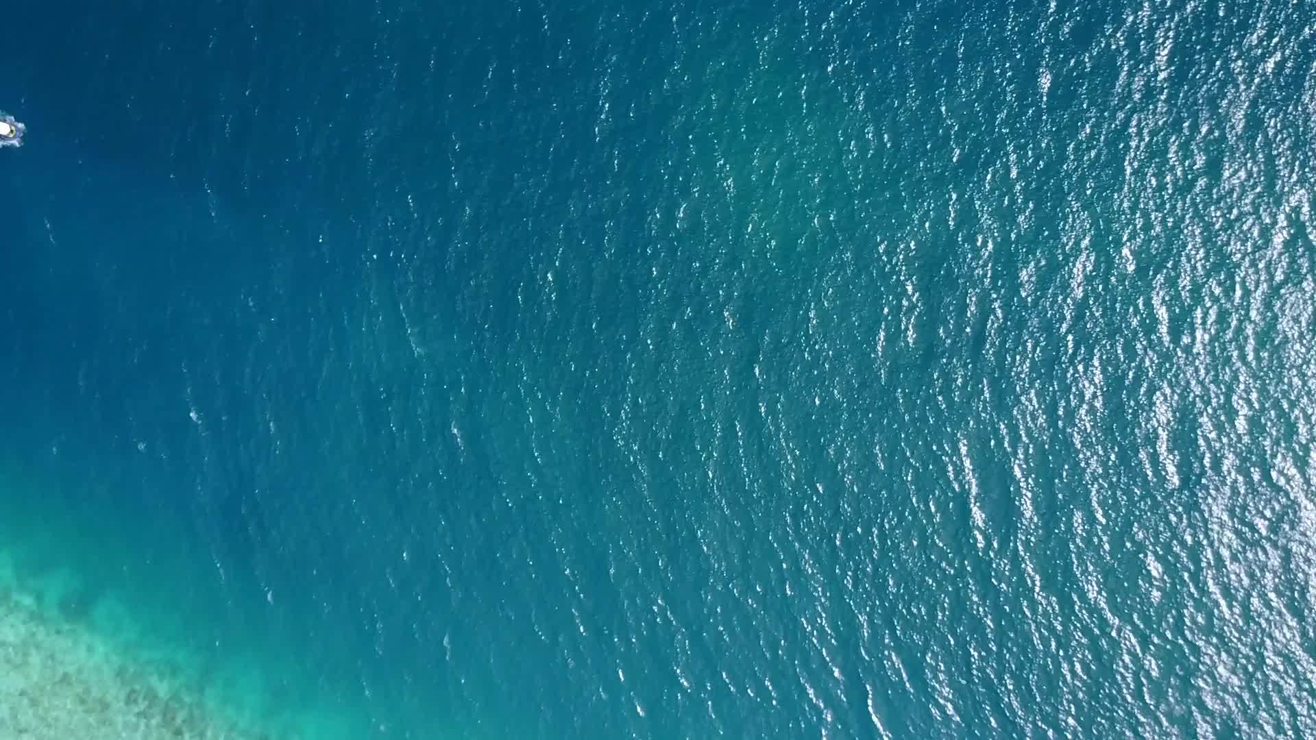 海平面以海浪附近的水蓝色环礁湖和白色海滩为基础视频的预览图