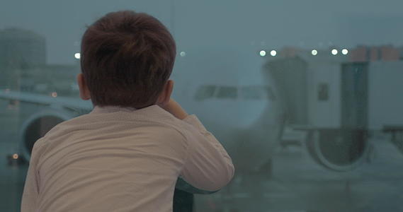 当等待飞行时好奇的男孩看着飞机视频的预览图