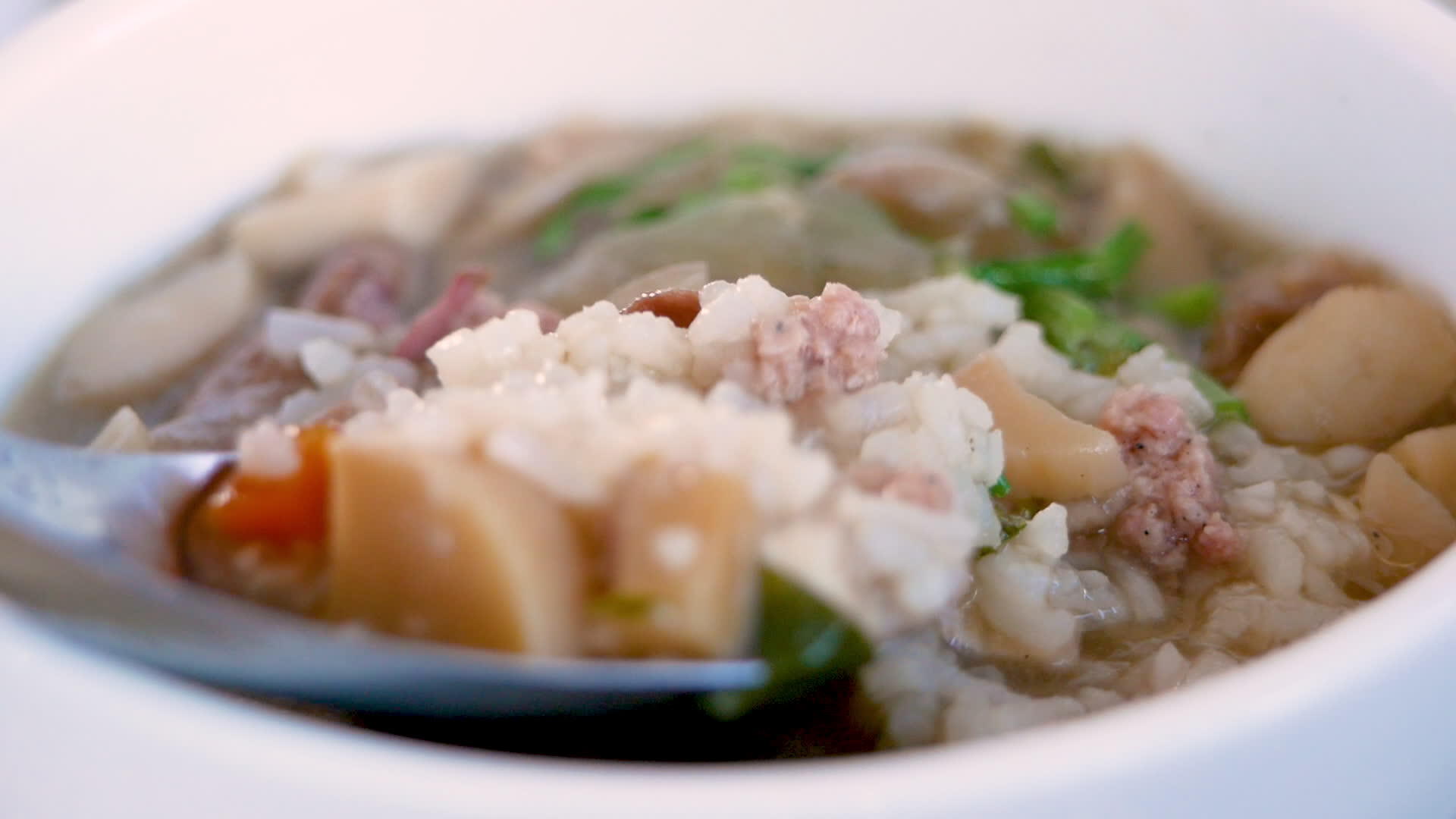 用猪肉蘑菇和蔬菜在碗里做饭的人视频的预览图