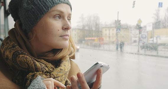 在城市坐公交车的路上女性用手机发短信视频的预览图