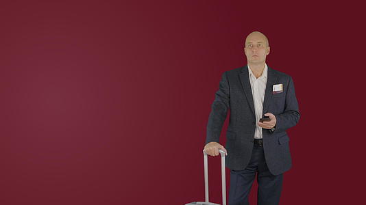 旅行商人的行李在红色背景下看手机的手提箱视频的预览图