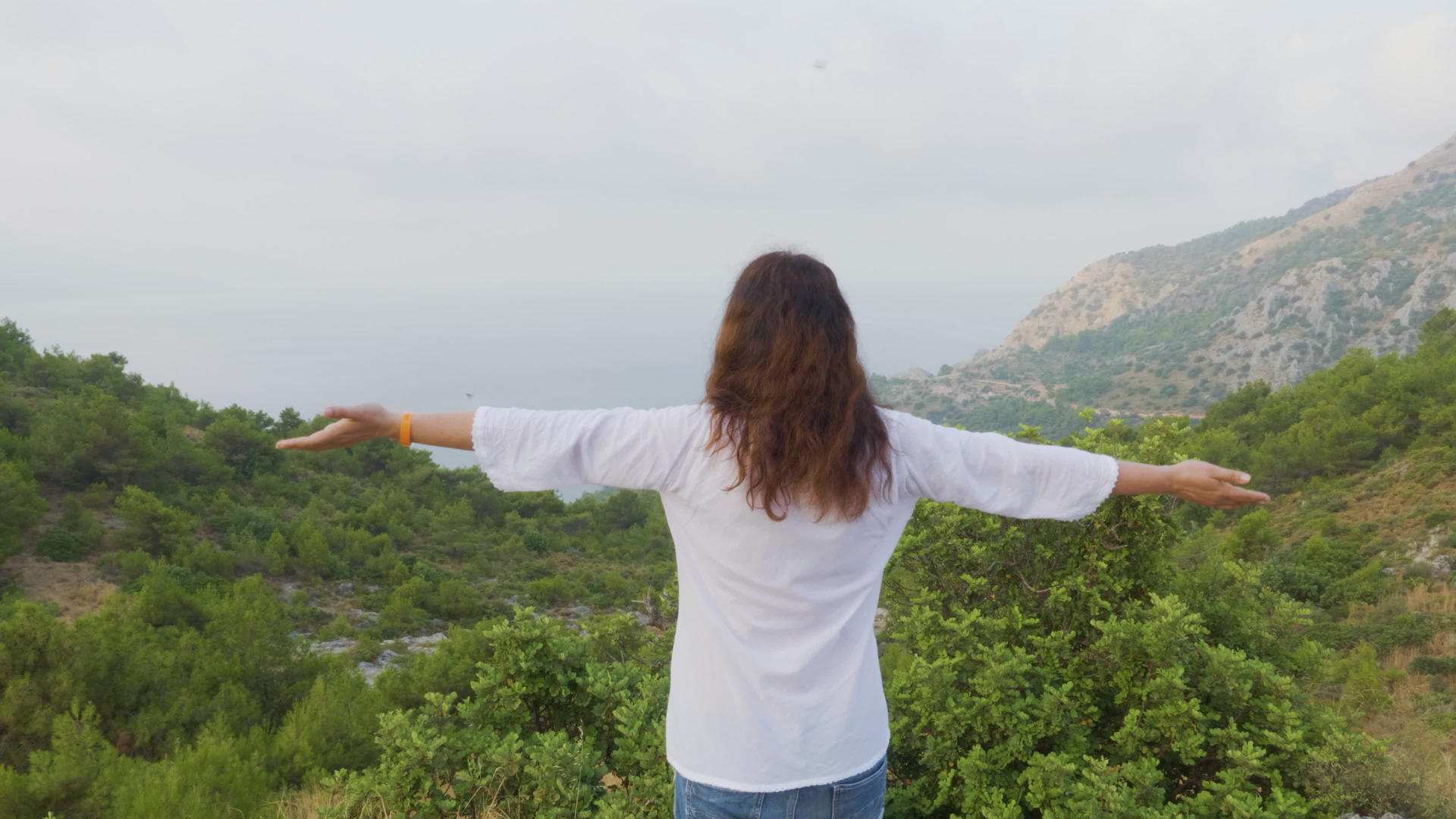 旅游妇女在雾山享受早晨的风景旅游妇女在山上伸出手视频的预览图