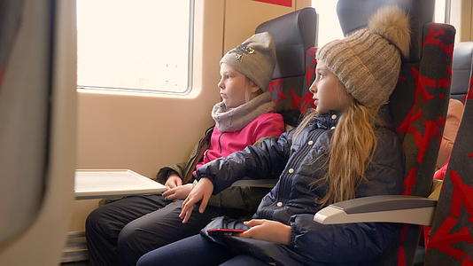 坐在火车上的乘客座位上女孩看着窗户旅行视频的预览图