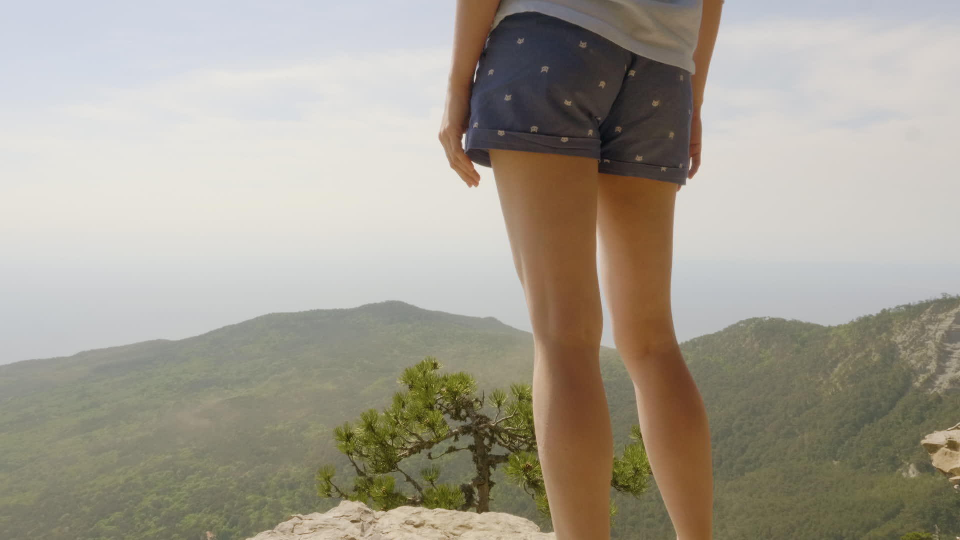 快乐的年轻女子站在山顶上看着美丽的风景漫游和旅行视频的预览图