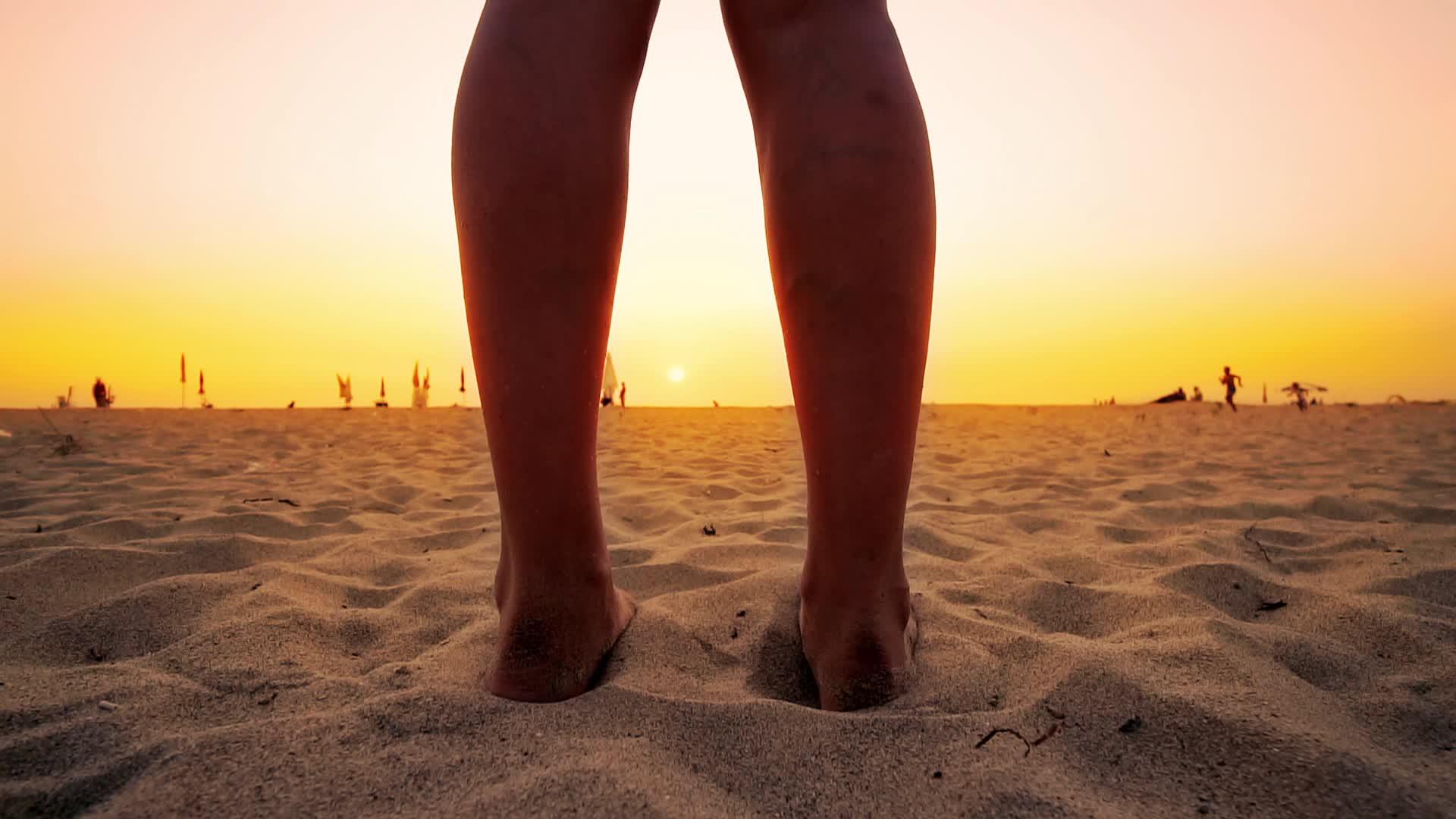 时尚女性站在沙滩上夏天的日落充满了活力和缓慢的动作视频的预览图