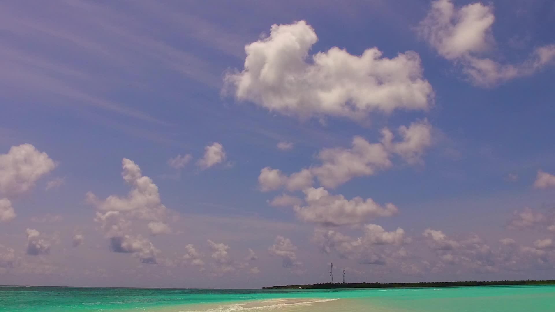 在蓝色海洋和暗礁附近的白色海滩的背景下视频的预览图