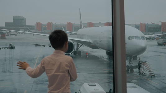 孩子们看着飞机穿过窗户看着孩子们视频的预览图