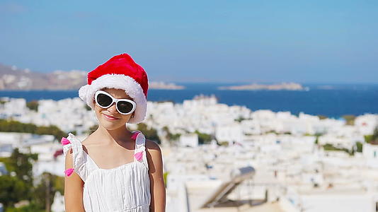 白色连衣裙和红色帽子户外米科诺斯岛背景的迷人女孩视频的预览图