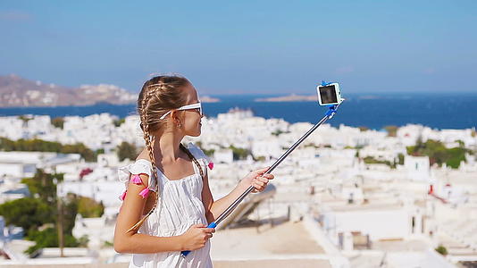 可爱的小女孩自拍照片背景konos镇在greece视频的预览图