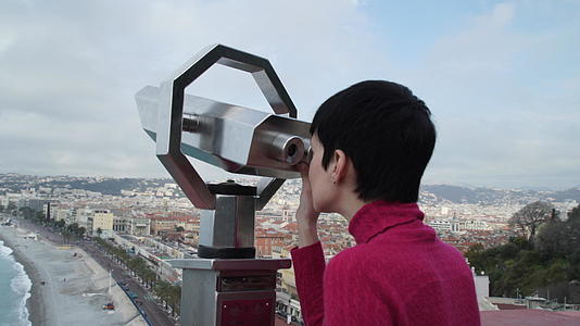 女游客通过望远镜观看城市景观视频的预览图