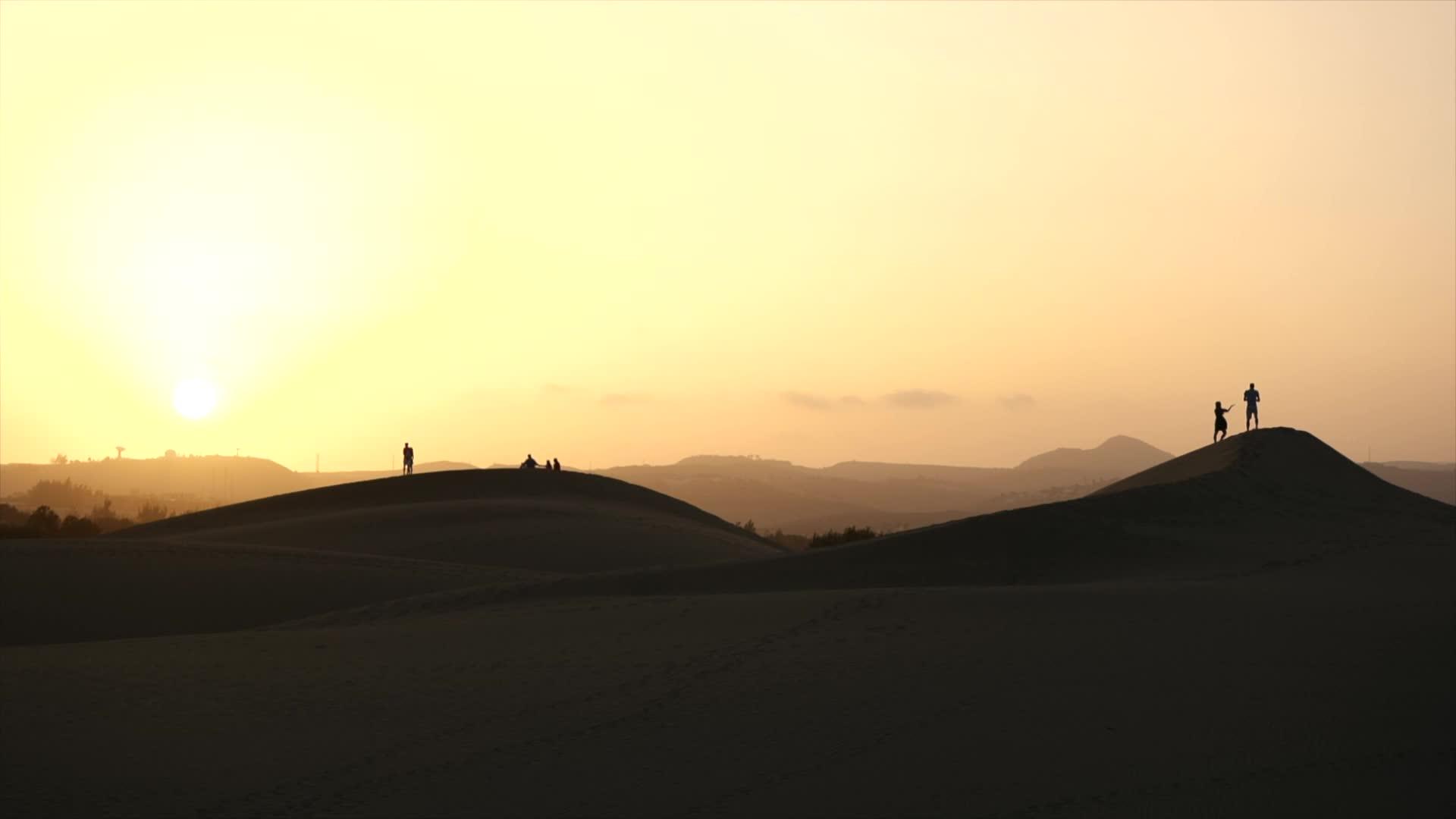 日落时在沙丘上行走视频的预览图