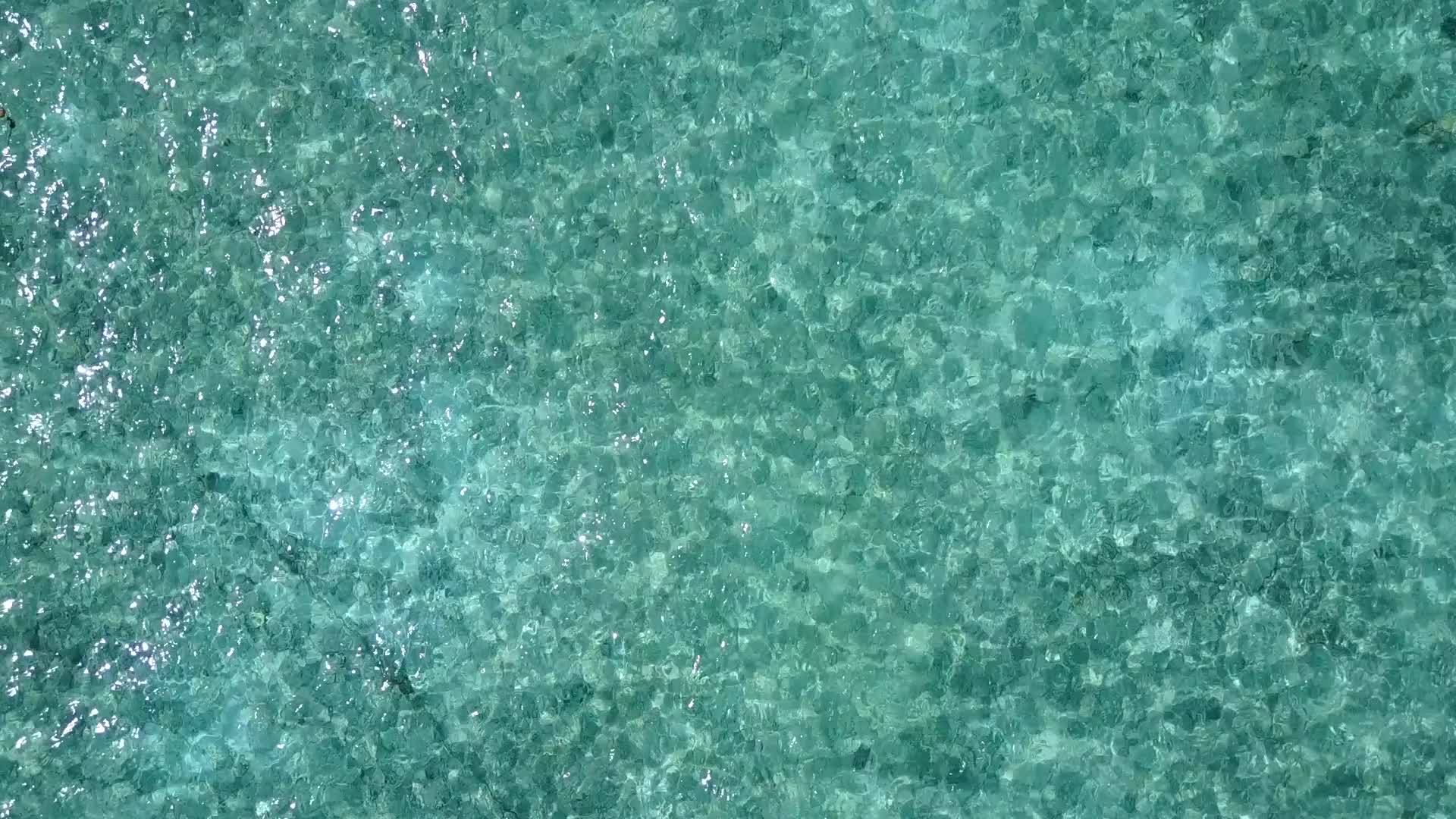以蓝海和白色沙底为背景在度假胜地附近有一个完美的海湾海滩视频的预览图