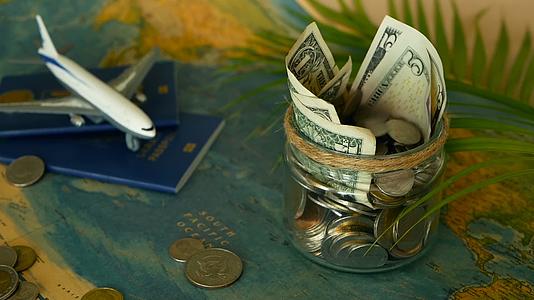 在世界地图背景的玻璃罐中旅行预算的概念是为假期省钱视频的预览图