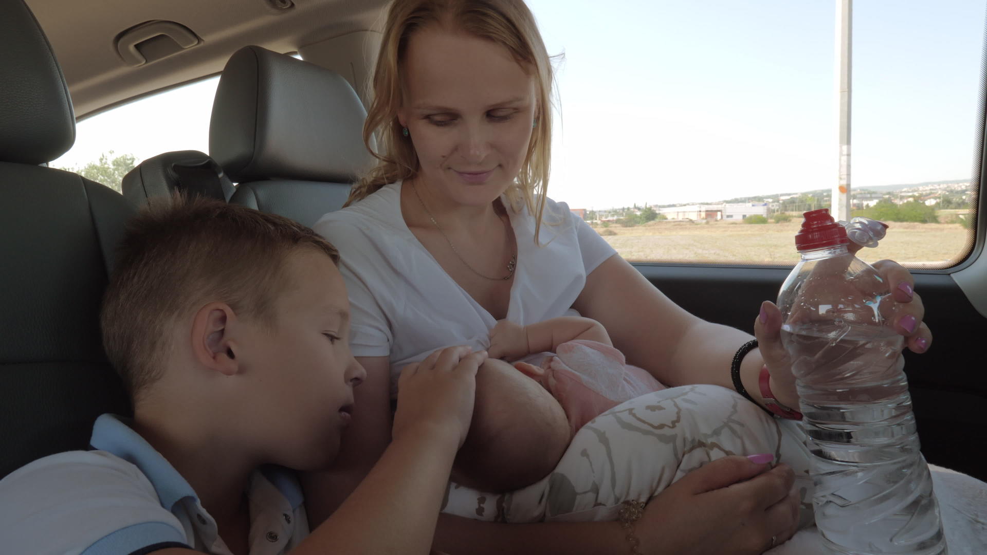 母亲的大儿子和婴儿在车里的情况视频的预览图