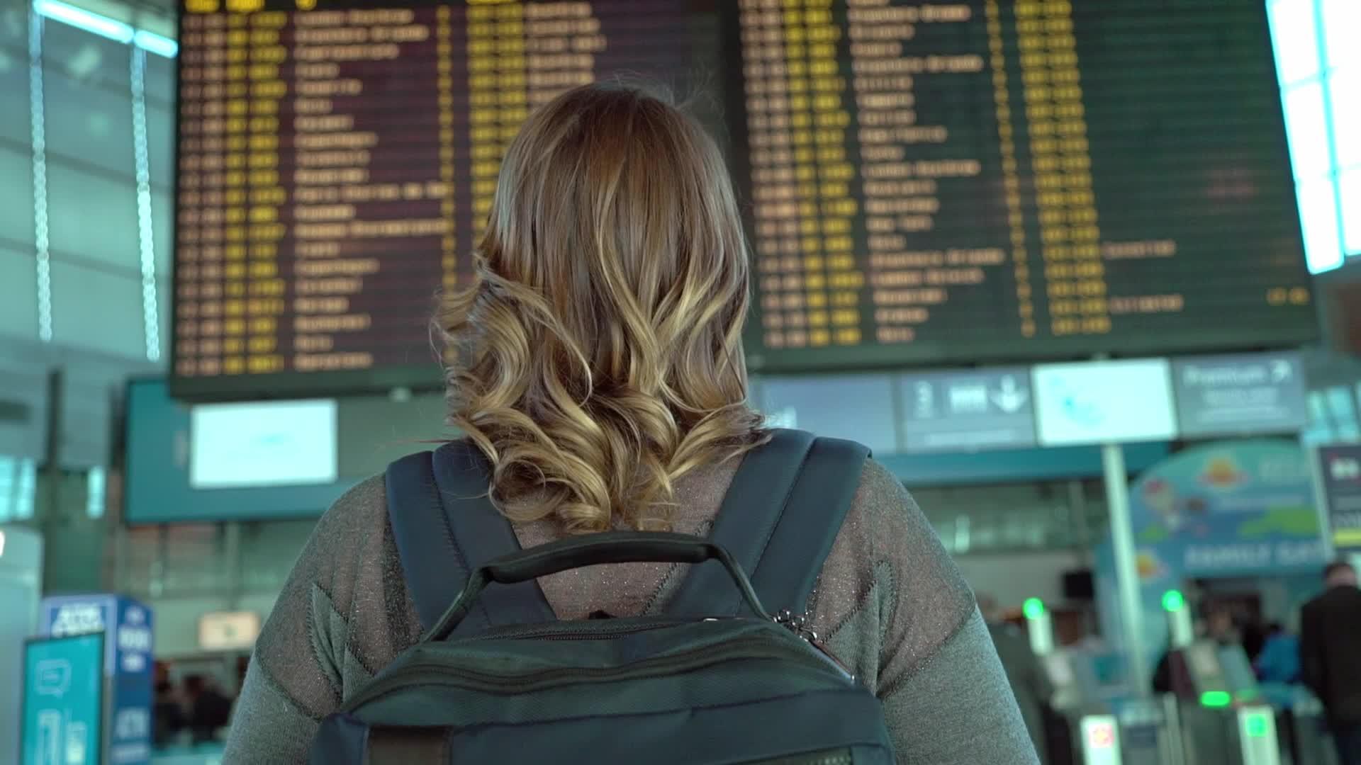 女性看机场信息栏视频的预览图