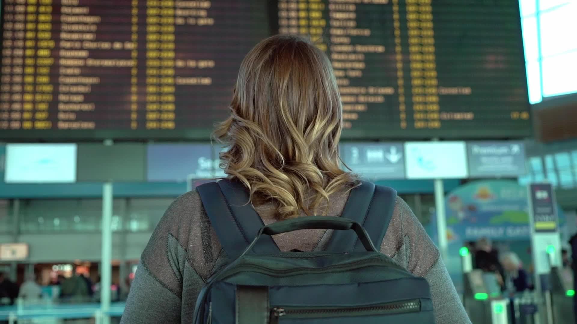 女性在机场信息栏查看女性数量视频的预览图