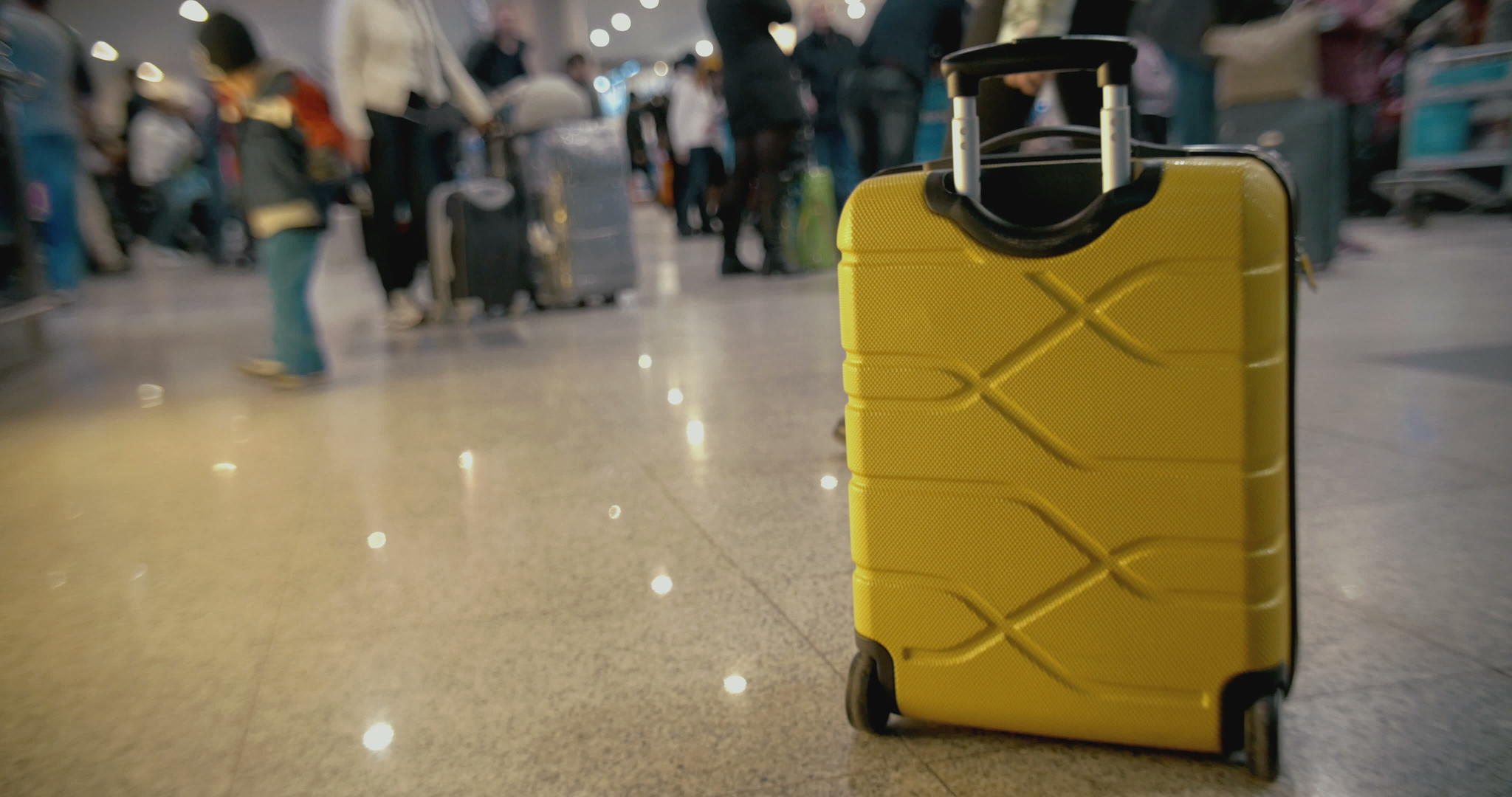 拥挤的机场地板上的黄色手提箱视频的预览图