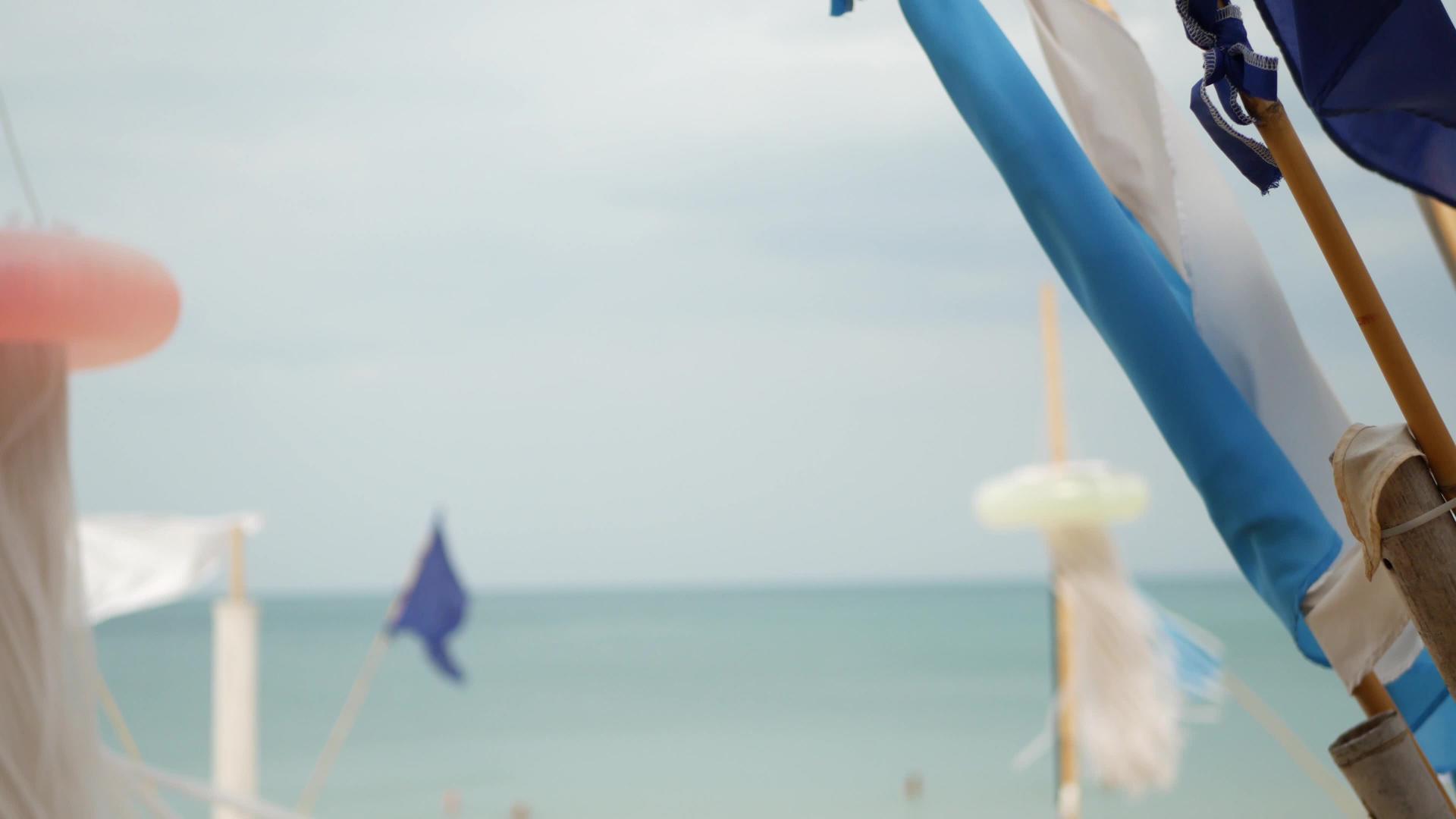 在热带海滩多云的天气里小三角蓝旗在风中飘扬视频的预览图