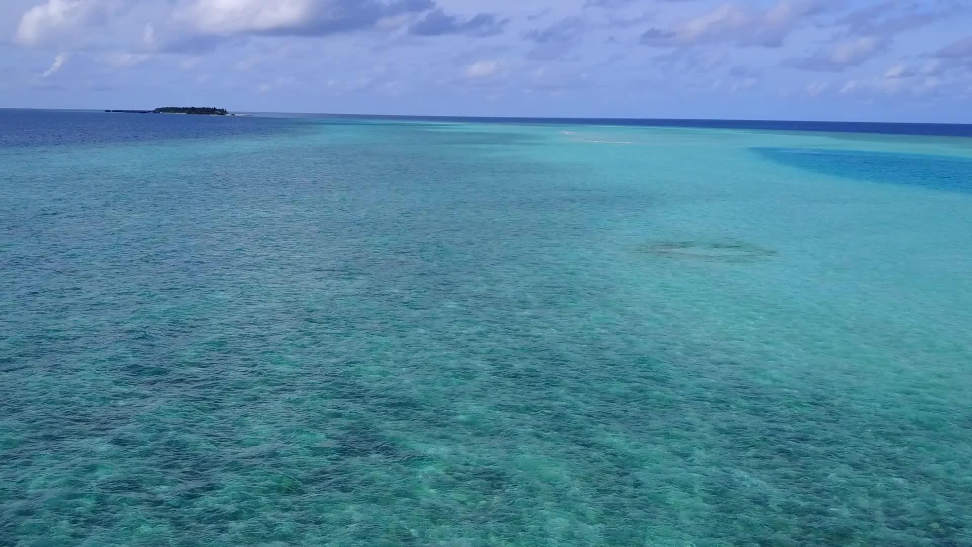 蓝绿色的水和白色的沙滩背景视频的预览图