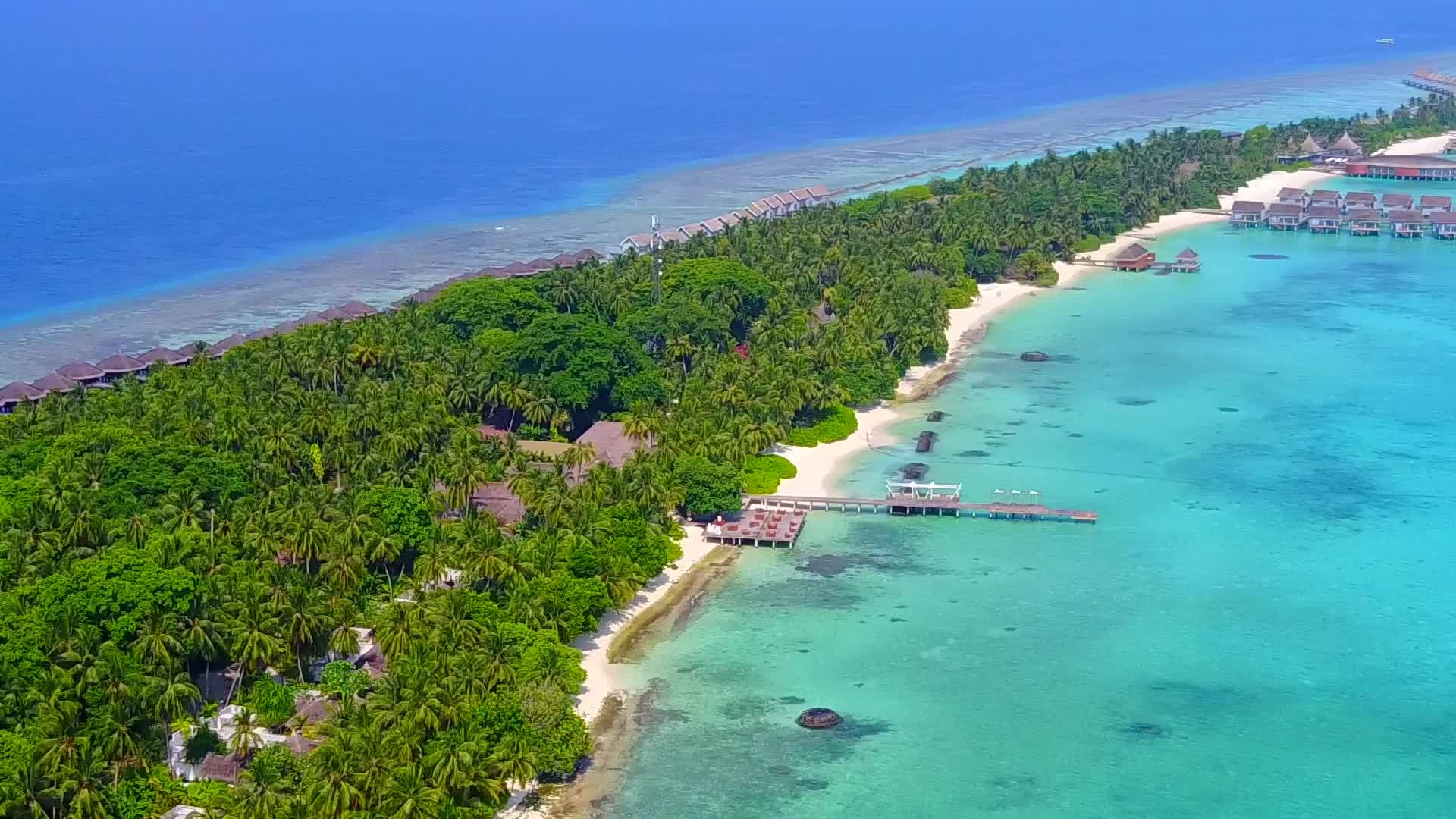 以透明环礁湖和明亮的沙地为背景观赏宁静的度假胜地视频的预览图