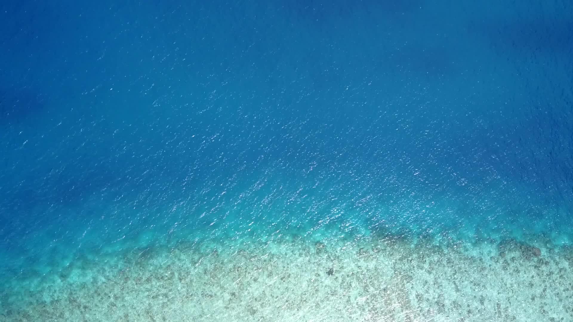 海风无人驾驶飞机沿着蓝海沿海海滩航行视频的预览图