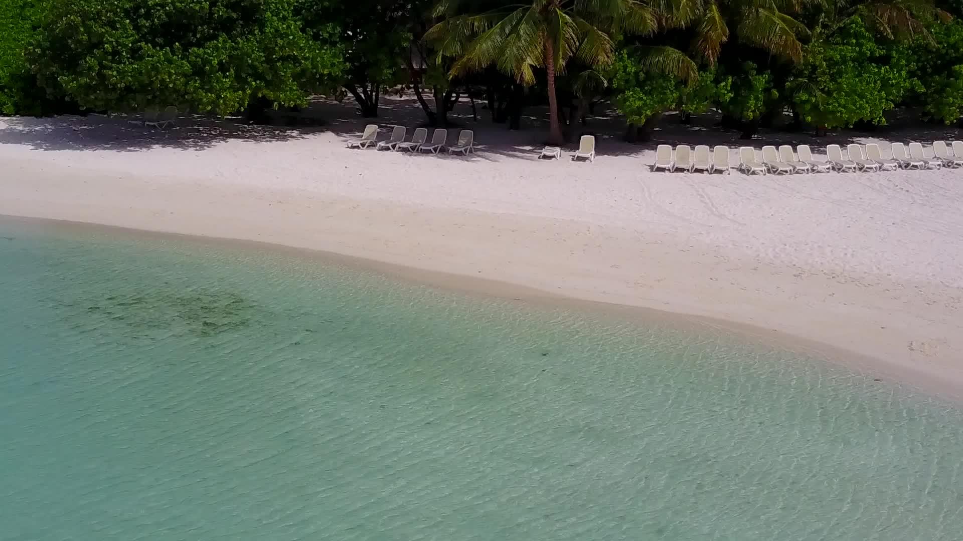 以水、蓝色环礁湖和白沙为背景的海面突破了海滩的风景空中无人驾驶视频的预览图