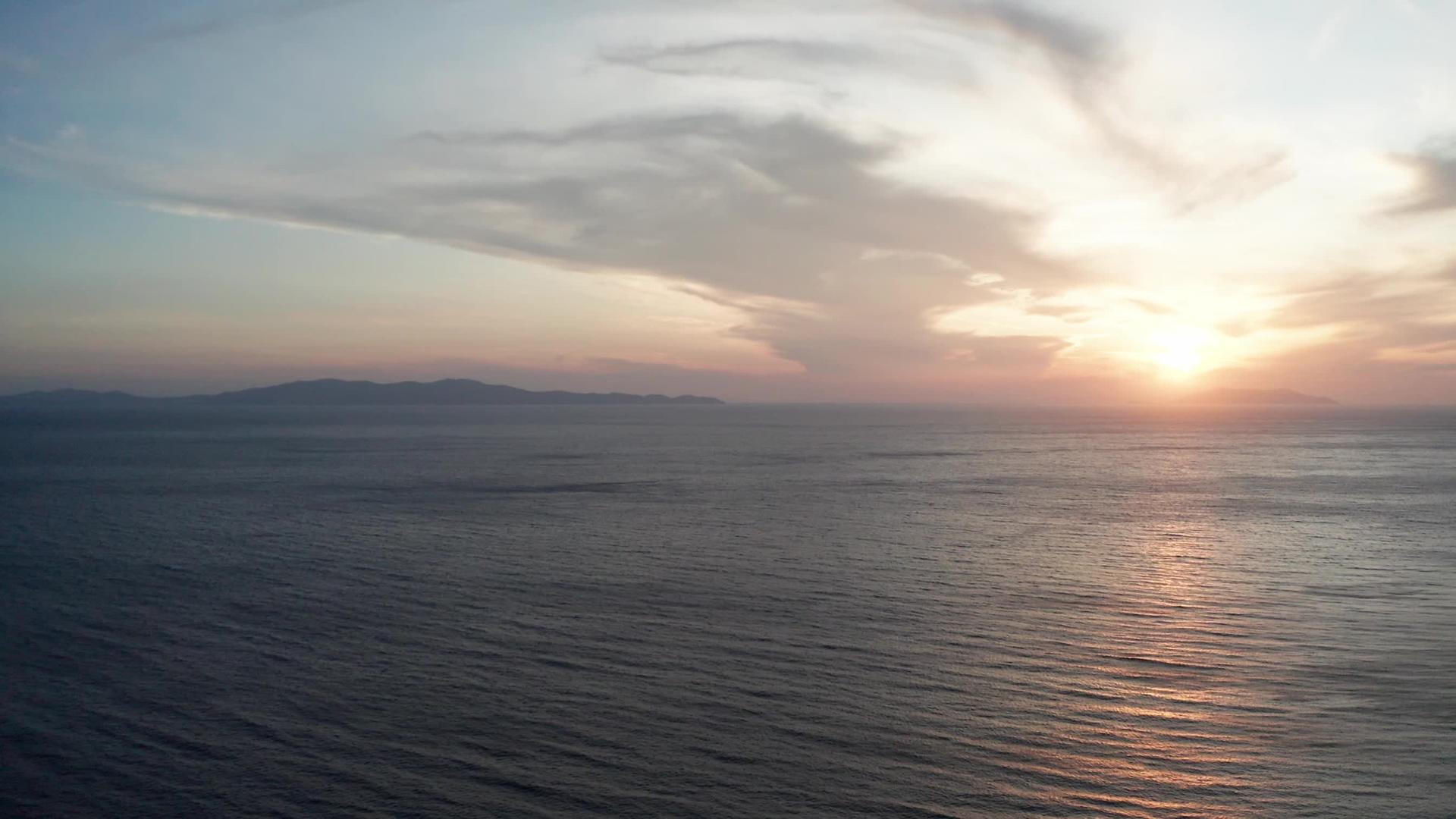 空中无人驾驶飞机环视着海平面上美丽的日落视频的预览图