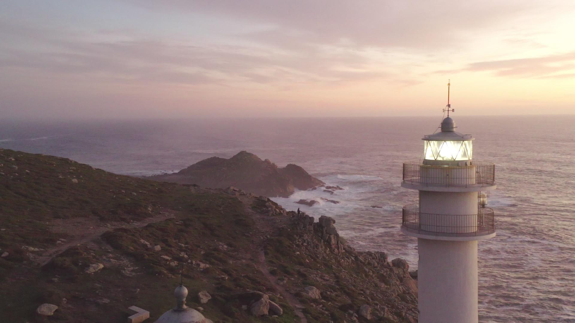 日落时可以在西班牙的海面上看到波贝托里南灯塔和粉红色视频的预览图