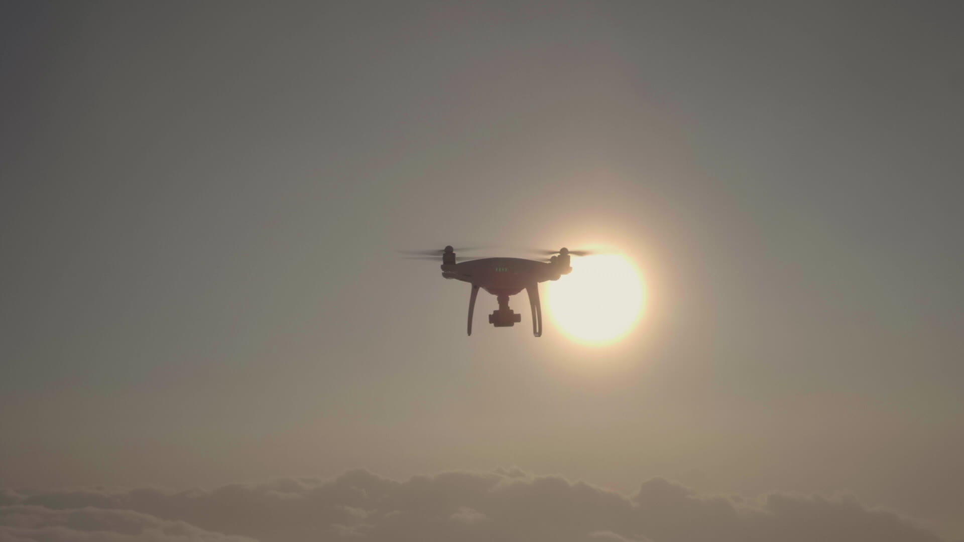 无人驾驶飞机飞向云的右侧重叠的太阳在空中观察慢动作视频的预览图